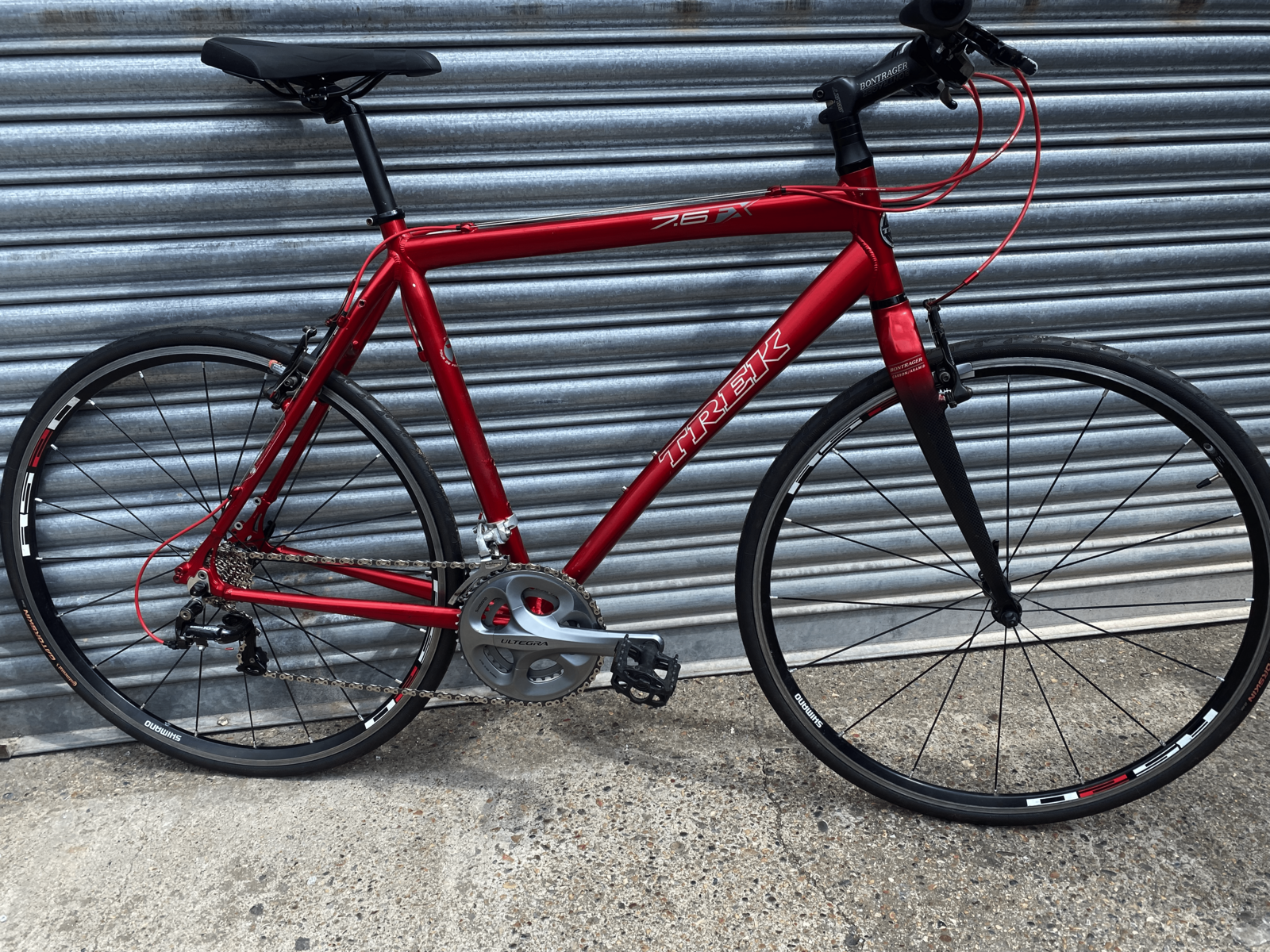 A customised bicycle with a red frame and wires.