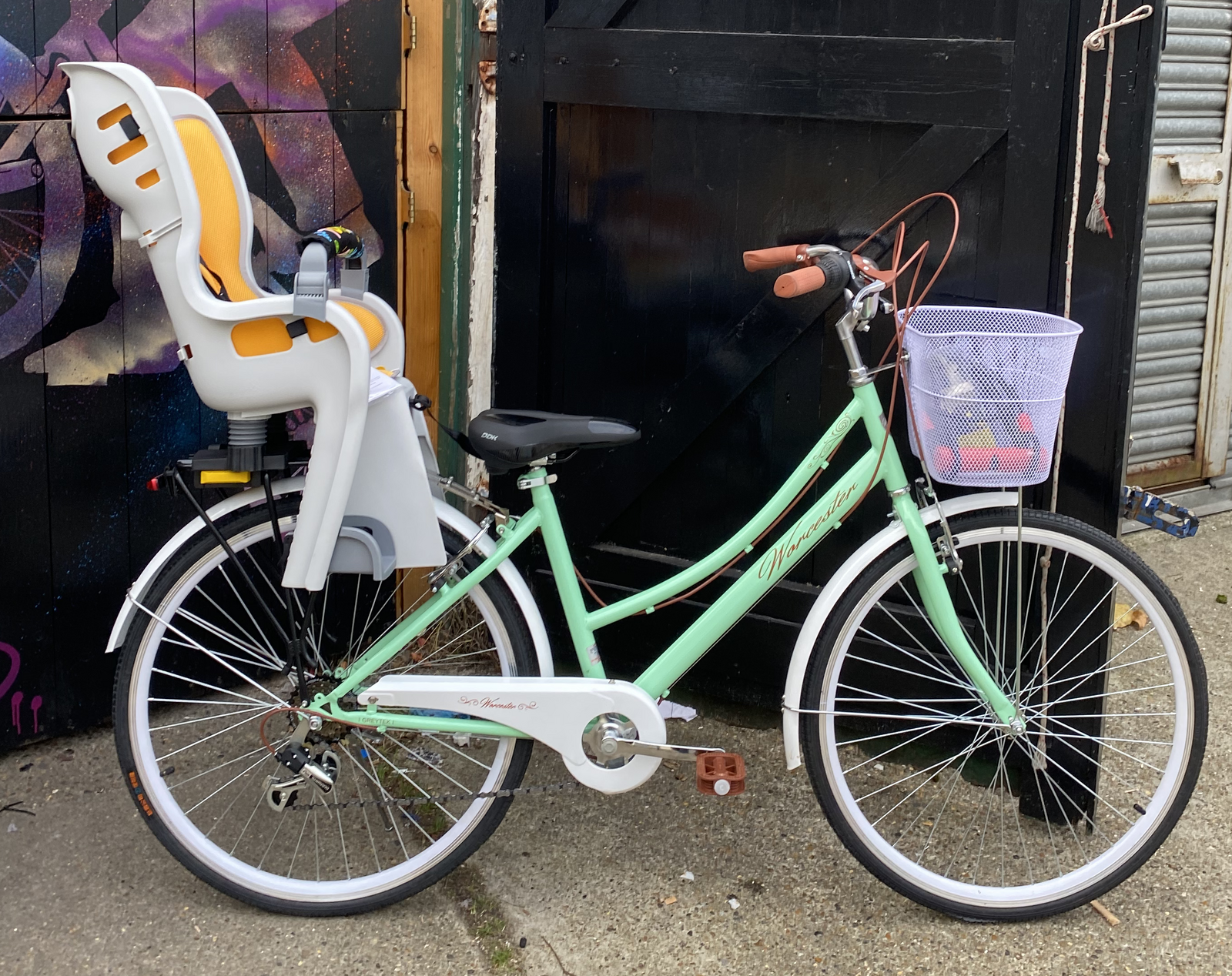 A colourful Holland bicycle with a child carrier.