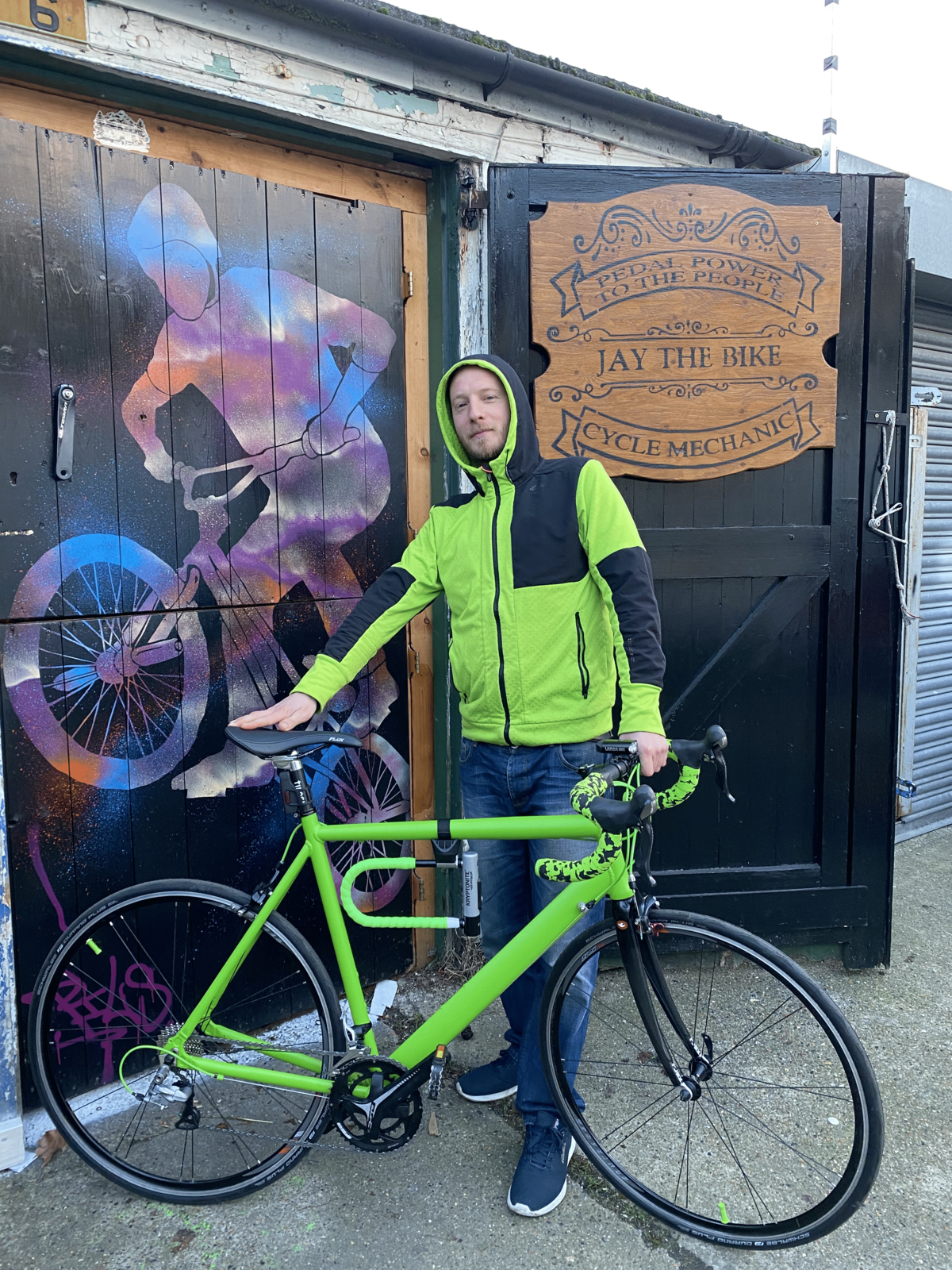 A pleased customer presenting his green themed bicycle.